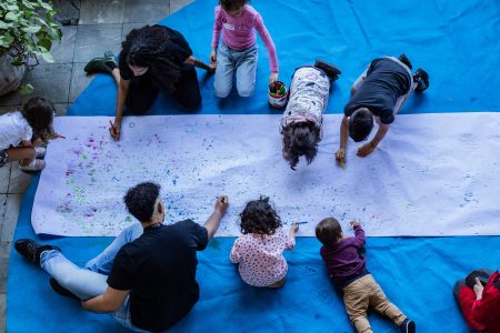 Foto de crianças e adultos desenhando durante uma atividade